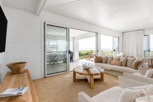 a living room with a couch and a table at The Beach House in Lennox Head