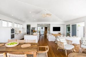 a kitchen and living room with a table and chairs at The Beach House in Lennox Head