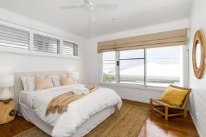 a white bedroom with a bed and a window at The Beach House in Lennox Head +37 photos
