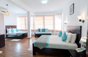 a hotel room with two beds and a couch at HillCrest Hotel in Kandy