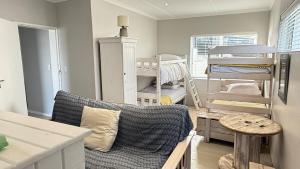 a living room with a couch and bunk beds at Blue-breaker view in Struisbaai