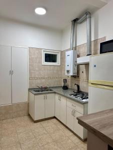a kitchen with white cabinets and a counter top at Departamento Lavanda in San Juan