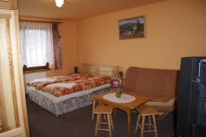 1 dormitorio con cama, sofá y mesa en Privat u Babky, en Ždiar