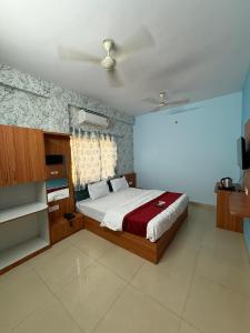 a bedroom with a bed with a red blanket at Hotel Sutlaj in Indore