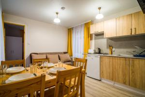 a kitchen and dining room with a table and chairs at Domek Parterowy in Gąski