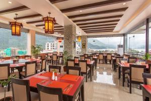 a restaurant with tables and chairs and large windows at Bodhi Suite Boutique Hotel & Wellness in Pokhara
