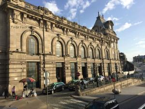 un grande edificio con auto parcheggiate di fronte di PortoVivo Bonjardim Apartamento a Porto