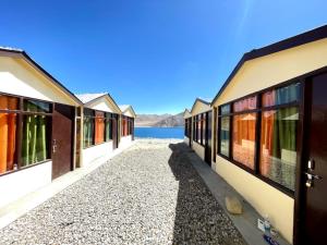 a row of houses next to a body of water at zoz camp pangong lake in Lukung