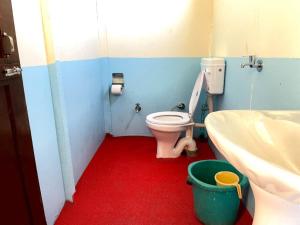 a small bathroom with a toilet and a sink at zoz camp pangong lake in Lukung