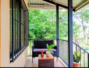 a screened in porch with a chair and a table at Cabañas y Senderos Finca El Triunfo in Los Chiles