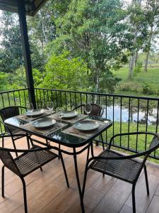 a table and chairs on a porch with a view at Cabañas y Senderos Finca El Triunfo in Los Chiles