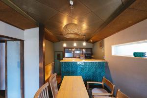 a dining room with a wooden table and chairs at oribe guesthouse in Tajimi