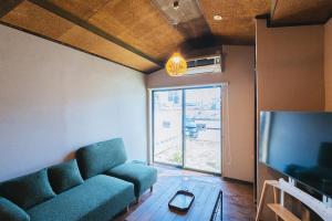 a living room with a couch and a tv at oribe guesthouse in Tajimi