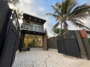a house with a gate and a palm tree at AB Villa in Hikkaduwa