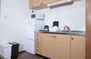 a small kitchen with a sink and a refrigerator at Shinka Hotel Susukino in Sapporo +18 photos