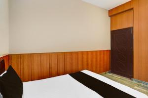 a bedroom with a bed with a wooden wall at Super Hotel O Dehradun City Centre Formerly Downtown in Dehradun