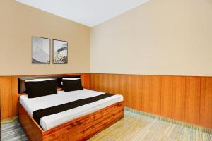 a bedroom with a bed in a room with wood paneling at Super Hotel O Dehradun City Centre Formerly Downtown in Dehradun