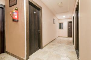 a hallway with a fire extinguisher on the wall at Hotel O Raipur City Center Formerly South Inn in Raipur