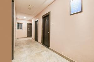 a hallway with black doors and a tile floor at Hotel O Raipur City Center Formerly South Inn in Raipur