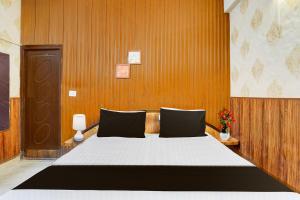 a bedroom with a large bed with a wooden wall at Super Hotel O Dehradun City Centre Formerly Downtown in Dehradun +32 photos