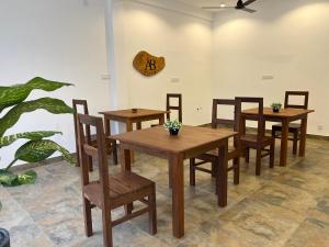 a dining room with wooden tables and chairs and a clock at AB Villa in Hikkaduwa +19 photos
