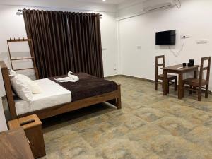 a bedroom with a bed and a table and a television at AB Villa in Hikkaduwa