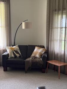 a living room with a black couch and a lamp at Annabelle's Cottage in Clare