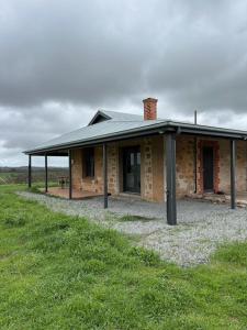 a brick house with a roof on a grass field at Annabelle's Cottage in Clare