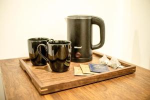 three coffee mugs on a wooden tray on a table at AB Villa in Hikkaduwa