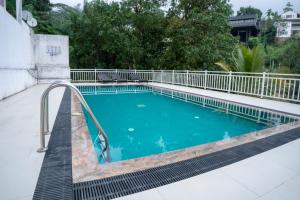 a swimming pool with a metal rail fence around it at HillCrest Hotel in Kandy