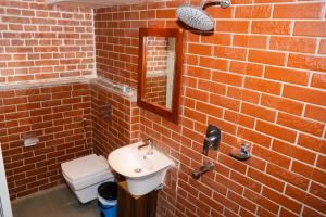 a brick bathroom with a sink and a mirror at Lamatar Hills Resort in Pātan +31 photos