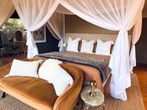 a bedroom with a large bed and a couch at Tula Retreat - Secluded Karoo Escape - Hot Tub - Private Boat Arrival in Calitzdorp