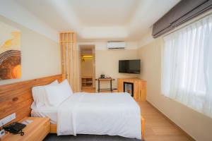 a bedroom with a white bed and a television at 31 Park Hotel in Pokhara
