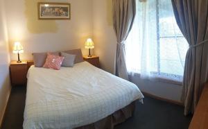 a bedroom with a white bed and a window at Riverview Coastal Retreat Sleeps 6 Walk to Beach Great Ocean Road in Peterborough