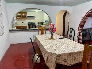 a dining room with a table with a vase of flowers on it at Casa de campo en Zacatlán in Zacatlán +10 photos