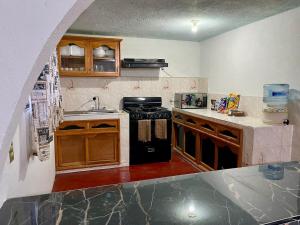 a kitchen with a black stove and a sink at Casa de campo en Zacatlán in Zacatlán