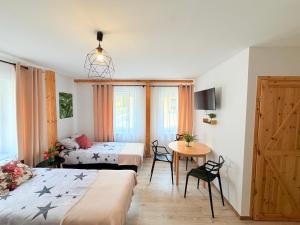 a room with two beds and a table and a bed at Noclegi Świerzawa 43 in Świerzawa