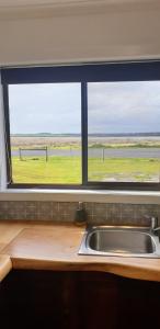 a window above a kitchen sink with a view of a field at Riverview Coastal Retreat Sleeps 6 Walk to Beach Great Ocean Road in Peterborough +22 photos