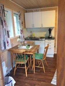 a small kitchen with a wooden table and chairs at Sponavik Camping in Stord