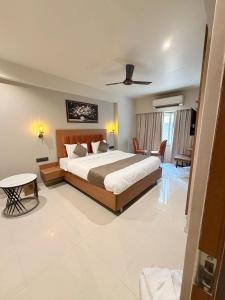 a bedroom with a large bed and a living room at Hotel Avenue Inn in Navi Mumbai