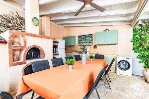 a dining room with an orange table and chairs at Cretan Dawn Apart, Value Option in Ammoudara in Ayía Marína