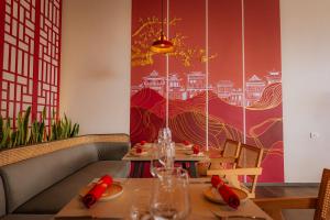 a dining room with two tables and a red wall at 31 Park Hotel in Pokhara