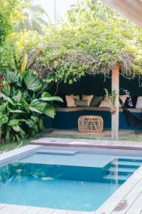 a pool with a seating area next to a garden at Marevka - Pool Villa with garden in General Luna
