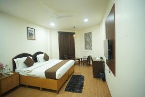 a hotel room with a bed and a television at Ruchi resort in Hisār