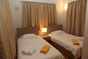 Dos camas en una habitación de hotel con toallas. en Anthorina Villa 20, en Protaras