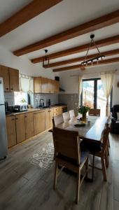 a kitchen with a dining room table and chairs at Casa de Sub Munte Cozy Chalet in Fundata
