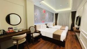 a hotel room with a bed and a desk and a mirror at Glory Hotel Vĩnh Yên in Nhân Mỹ