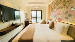 a hotel room with a large bed and a tv at Glory Hotel Vĩnh Yên in Nhân Mỹ