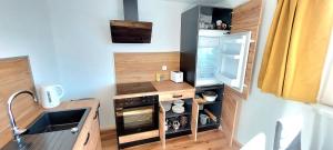 a small kitchen with a stove and a refrigerator at Alpenrose Ferienwohnung in Balderschwang