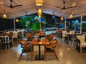 a restaurant with wooden tables and chairs and lights at Jackfruit in Arambol